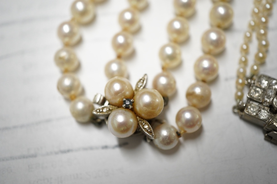 Two double strand cultured pearl necklaces, one graduated with paste set white metal clasp, 48cm, the other with cultured pearl set 9ct white gold clasp.